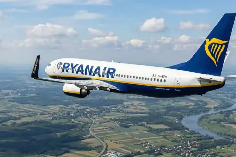 Samolot Ryanair leci nad zieloną krainą. Od kiedy loty tanich linii lotniczych stały się tak popularne?