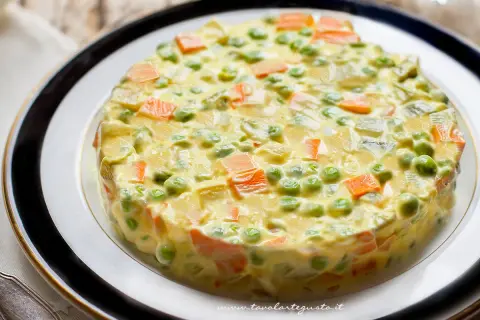 Insalata russa ricetta: un tortino cremoso di patate, carote, piselli e maionese, perfetto per ogni occasione.