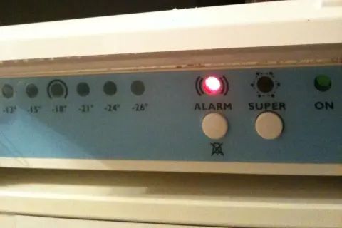 Panel kontrolny zamrażarki Whirlpool z migającą czerwoną diodą ALARM i przyciskami SUPER i ON.