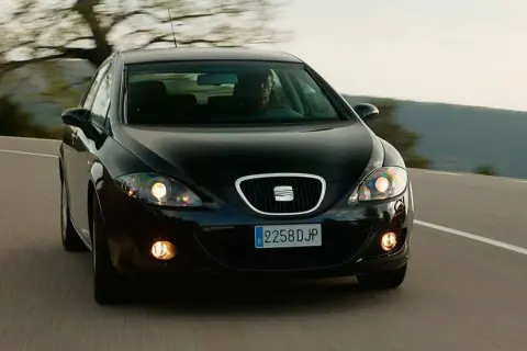 Czarny Seat Leon 2 z 2006 roku na zakręcie drogi.