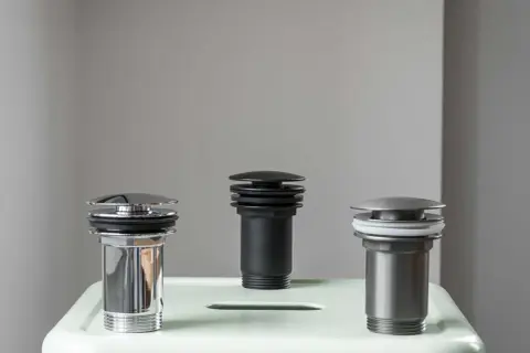 Trzy korki klik klak w różnych kolorach i wykończeniach. Dowiedz się, jak naprawić korek klik klak.