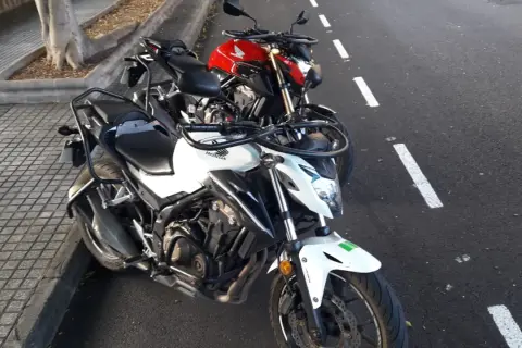 Dos motos Honda, una blanca y otra roja, aparcadas en la calle. ¿Listo para obtener tu carnet a como sacarlo?