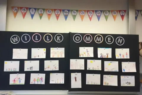 Willkommen zum Elternabend Grundschule! Kinderzeichnungen schmücken die Tafel.