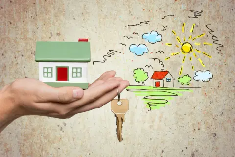 Hand hält Hausmodell & Schlüssel. Traumhaus-Zeichnung mit Sonne & Wolken. Gute Aussichten für die immobilienkauffrau ausbildung gehalt.