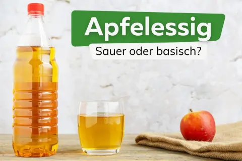 Apfelessig: sauer oder basisch? Eine Flasche und ein Glas mit goldgelbem Apfelessig stehen neben einem roten Apfel.