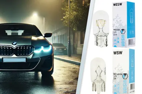 Srebrne BMW z włączonymi światłami pozycyjnymi na mokrej ulicy nocą. Obok żarówki Vision W21W, W16W, W5W, H6W.