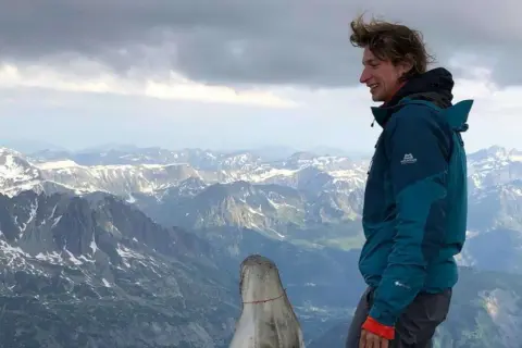 Robert Grasegger genießt die Aussicht auf schneebedeckte Berge.