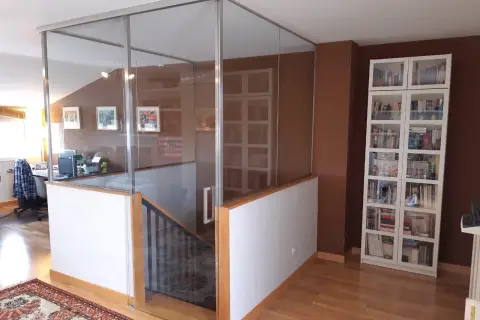Modern glass enclosure around open stairs, creating a safe and stylish way como cerrar escaleras abiertas.