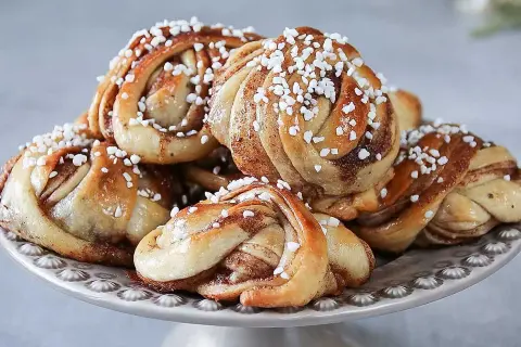 En hög med nybakade kanelbullar, perfekta för ett kanelbullar recept. Strösslade med pärlsocker.