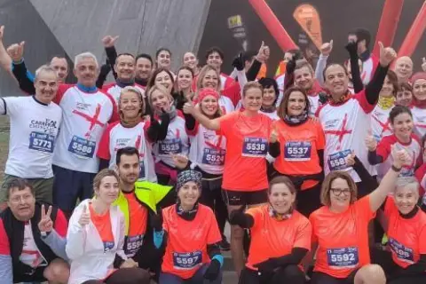 Grupo sonriente posa antes de la carrera de empresas en Zaragoza.