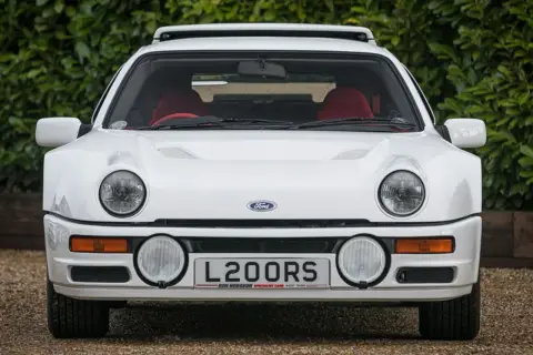 Vit Ford RS200 med röda säten, redo för rally.