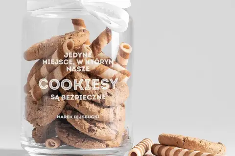 Słoik pełen ciastek, z białym napisem "COOKIESY SĄ BEZPIECZNE".