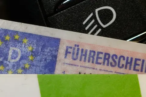 Führerschein mit EU-Sternen und "D" für Deutschland, daneben ein Lichtschalter. Bereit für die Fahrt nach § 24 StVG.