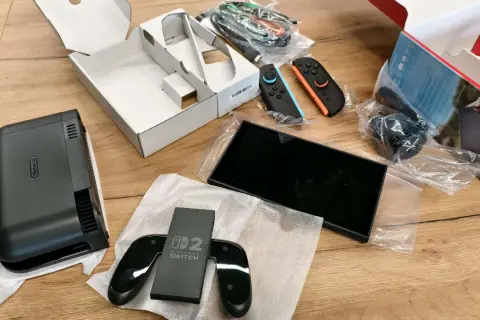 Zawartość pudełka Nintendo Switch: konsola, dwa kontrolery Joy-Con (niebieski i pomarańczowy), stacja dokująca i kable.