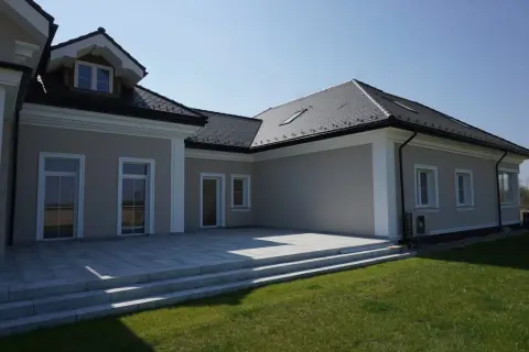 Nowoczesny dom z tarasem i schodami. Elegancki gzyms podkreśla architekturę budynku.