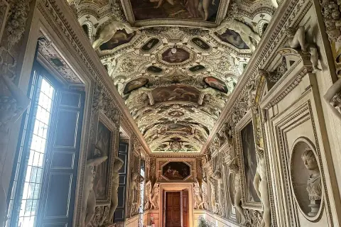 Corridoio decorato con affreschi e sculture nel **Palazzo Spada Roma**. Soffitto a volta con scene mitologiche e figure allegoriche.