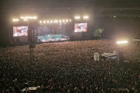 Ogromny tłum na koncercie Iron Maiden w Warszawie. Na scenie zespół, a na telebimach zbliżenia.