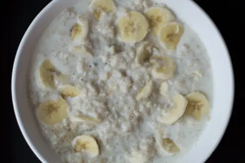 Miseczka owsianki z bananem. Kto nie powinien jeść płatków owsianych? Osoby z nietolerancją glutenu lub celiakią powinny unikać tradycyjnych płatków.
