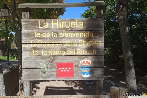Cartel de madera da la bienvenida a La Hiruela, Reserva de la Biosfera de la Sierra del Rincón. Aquí te indicamos la hiruela como llegar.