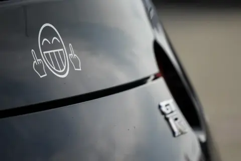 Lachendes Smiley-Gesicht mit Mittelfingern als Aufkleber am Auto. Welche Aufkleber am Auto sind erlaubt?