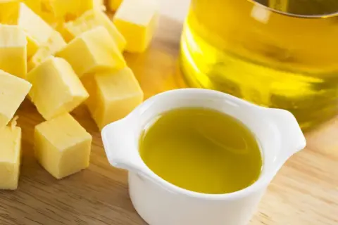 Würfel von Butter und ein Schälchen mit Öl. Fette Chemie für köstliche Gerichte.