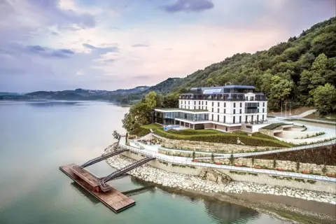 Nowoczesny hotel nad jeziorem, idealny na romantyczne miejsca w Polsce. Widok na wodę, las i pomost.