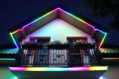 Kolorowa taśma LED w podbitce dachowej tworzy tęczową iluminację wokół domu, dodając mu magicznego blasku.