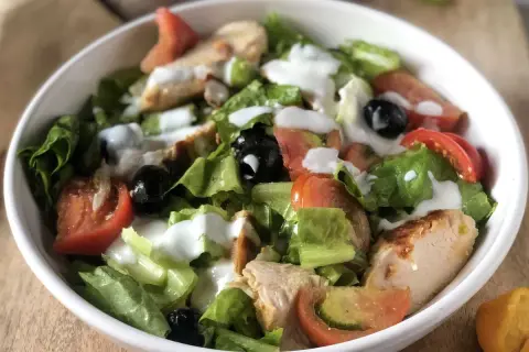 Insalata di pollo sfiziosa con lattuga croccante, pomodoro, olive nere e un dressing cremoso. Perfetta per un pasto leggero e gustoso.