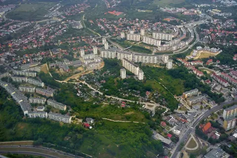 Widok z lotu ptaka na osiedle mieszkaniowe w Gdańsku Suchanino. Długie bloki mieszkalne otoczone zielenią i drzewami.