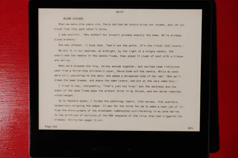 Extrait d'un livre lu sur une liseuse, le texte "Blood Sisters" est affiché en police Atkinson Hyperlegible.