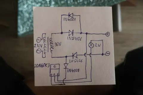Rysunek schematu prostownika 12V z transformatorem, diodami i żarówką.