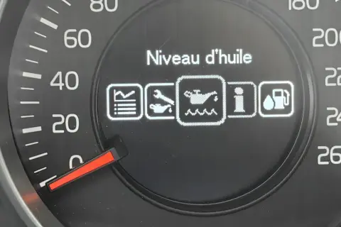 Na desce rozdzielczej Volvo V40 wyświetla się komunikat "Niveau d'huile" (poziom oleju) z ikoną wskazującą, że poziom oleju jest niedostępny.