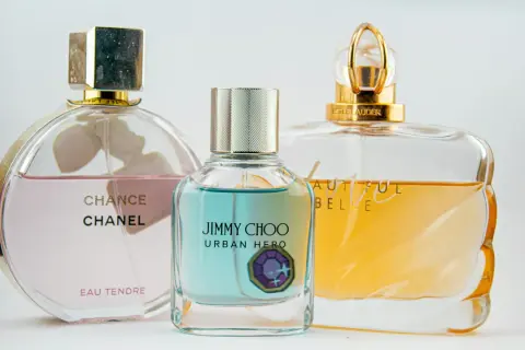 Trzy flakony perfum: Chanel Chance Eau Tendre, Jimmy Choo Urban Hero i Estee Lauder Beautiful. Różne rodzaje edp vs edt.