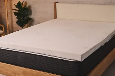 A new mattress with a white topper. This image helps answer: should I put a mattress topper on a new mattress?