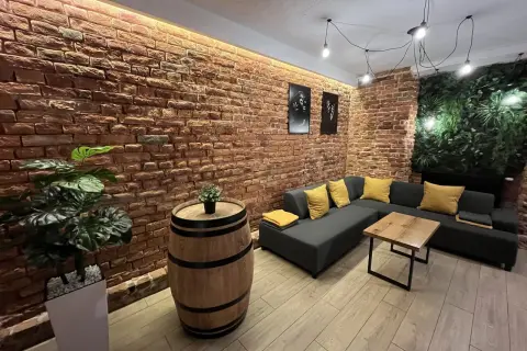 Przytulny lokal na 18 urodziny w Lublinie. Ceglana ściana, wygodna kanapa i beczka jako stolik tworzą niepowtarzalny klimat.