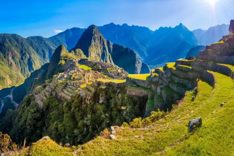 Machu Picchu w Peru, z tarasami i górami w tle. Planując podróż, warto pamiętać o **peru szczepienia**.