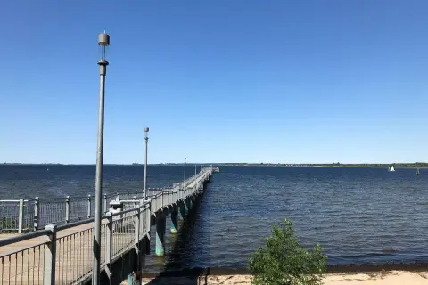 Langer Steg am Wismar Strand, der ins tiefblaue Wasser führt. Ein perfekter Ort für einen Spaziergang.