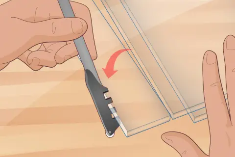 Hands demonstrate how to cut glass with a scoring tool, creating a clean line on the material.