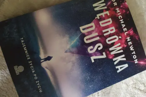 Okładka książki "Wędrówka dusz" Dr Michaela Newtona. Sylwetka człowieka na tle kosmicznego krajobrazu.