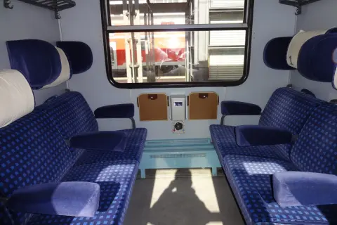 Wnętrze wagonu Intercity z niebieskimi siedzeniami. Czekam, aż zwolnią się miejsca dla niepełnosprawnych.