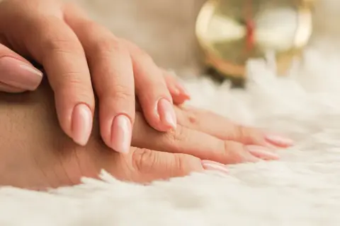 Delikatne dłonie z różowym, naturalnym lakierem. Idealny manicure biologiczny dla każdej kobiety.