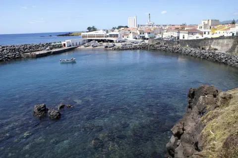 Malowniczy port na Azorach, idealne miejsce na wakacje. Woda jest krystalicznie czysta, widać łodzie i budynki.