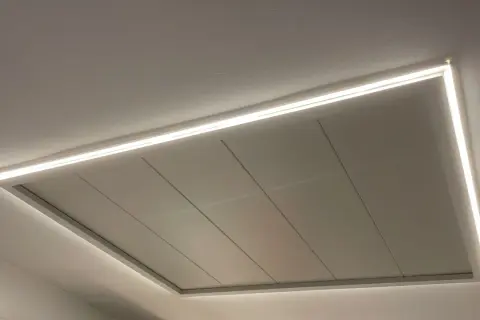 Un moderno falso techo con iluminación LED integrada, creando un ambiente acogedor.