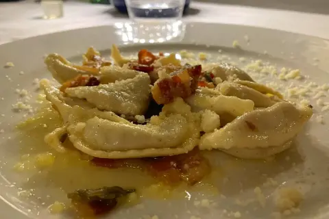 Pyszne pierożki z ricottą i szpinakiem, posypane parmezanem. Idealne pytanie: co zjeść w Bergamo?