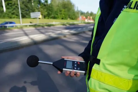 Policjant mierzy poziom hałasu. Sprawdza, ile decybeli może mieć auto, by nie przekraczać norm.