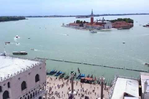Vista aerea di Venezia con l'isola di San Giorgio in lontananza, gondole e piazza San Marco in primo piano.