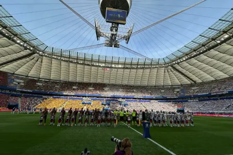 Piłkarze i dzieci stoją na murawie stadionu przed meczem Pucharu Polski.