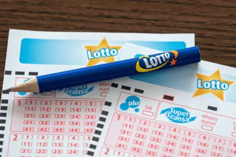 Niebieski ołówek spoczywa na kuponach Lotto. Czy w lotto wygrywa średnio co czwarty kupon? Szansa na wygraną jest zawsze!