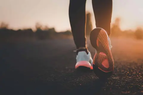 Scarpe da corsa al tramonto, un passo dopo l'altro per bruciare calorie camminata.