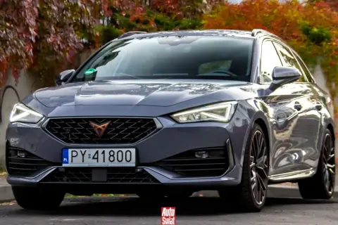 Szary Cupra kombi z jesiennymi liśćmi w tle.